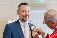 Toastmaster assisting Groom with buttonhole