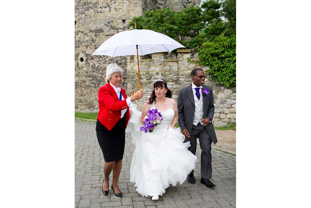 Lady Toastmaster carrying umbrella for Bride